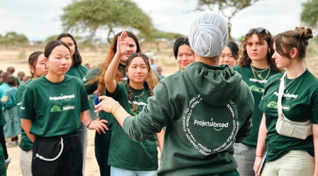タンザニアでミーティング中に手を上げる日本人高校生ボラティア